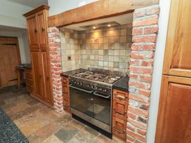 A kitchen with a stove and cabinets at Rose House in Alnmouth