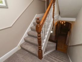 A staircase with a banister in a hallway at Rose House Alnmouth