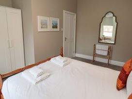 A bedroom with a bed and wardrobe at Rose House in Alnmouth