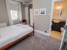 A bedroom with a bed and an attached bathroom at Rose House in Alnmouth