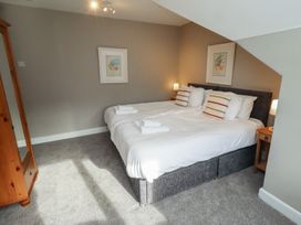 A bedroom with two beds and a nightstand at Rose House in Alnmouth