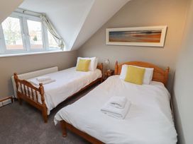 A bedroom with two single beds and a window at Rose House in Alnmouth