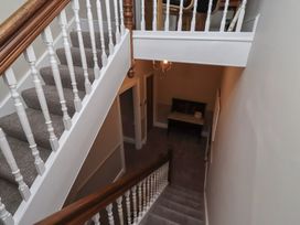 A staircase with a landing and a table at Rose House in Alnmouth