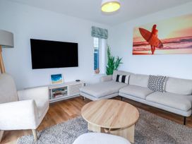 A living room with a television and sofa at Lavender House in Crantock