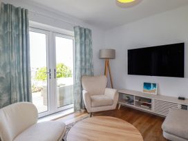 A living room with a television and seating area at Lavender House in Crantock