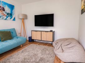 A living room with a sofa and television at Lavender House in Crantock