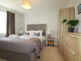 A bedroom with a bed, nightstand and wardrobe at Lavender House in Crantock