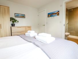 A bedroom with a bed and towels at Lavender House in Crantock