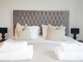 A bedroom with a bed, pillows, and lamps at Lavender House in Crantock