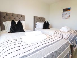 A bedroom with two beds and towels at Lavender House in Crantock
