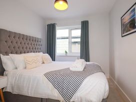 A bedroom with a bed and a window at Lavender House in Crantock