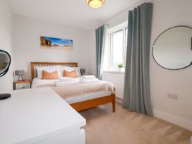A bedroom with a bed and side table at Lavender House in Crantock