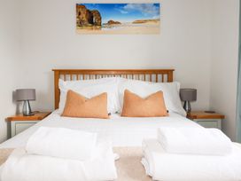 A bedroom with a bed and lamps at Lavender House in Crantock