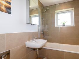 A bathroom with a bath tub and sink at Lavender House in Crantock
