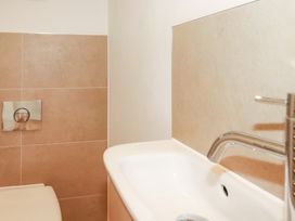A bathroom with a toilet, sink, and flush panel at Lavender House in Crantock