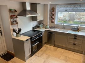 A kitchen with stove, sink and cupboard at Woodbine Cottage, Mylor Bridge, Nr Falmouth