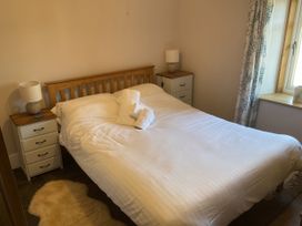 A bedroom with a bed and two bedside tables at Woodbine Cottage, Mylor Bridge, Nr Falmouth