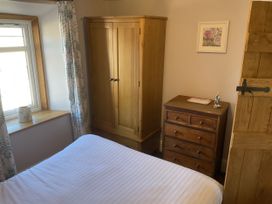 A bedroom with bed, wardrobe, and chest of drawers at Woodbine Cottage Mylor Bridge Nr Falmouth