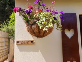 A flower basket and sign at Turnpike Lodge in Brixham