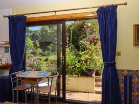 A dining room with a table and chairs overlooking a garden at Turnpike Lodge in Brixham