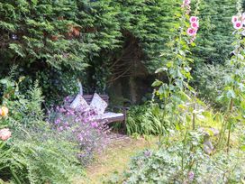 A garden with a bench and flowers at Turnpike Lodge Brixham