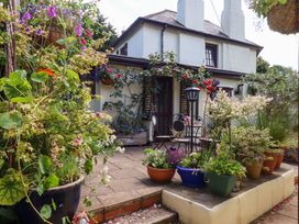A garden with planters and a table with chairs at Turnpike Lodge in Brixham
