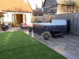 A garden with a hot tub and seating area at The Stables at Hall Barn Wattisfield near Walsham-Le-Willows