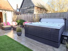 A garden with a hot tub and outdoor seating at The Stables at Hall Barn Wattisfield near Walsham-Le-Willows