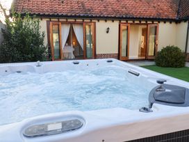 A hot tub with spray and open doors at The Stables at Hall Barn Wattisfield near Walsham-Le-Willows