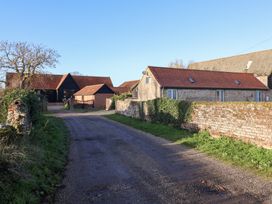 An outdoor view of barns and a house at The Stables at Hall Barn Wattisfield near Walsham-Le-Willows