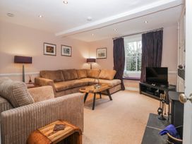 A living room with a sofa and television at The Old Book Shop in Cartmel