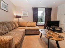 A living room with a sofa and television at The Old Book Shop in Cartmel