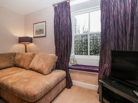 A living room with a sofa and television at The Old Book Shop in Cartmel
