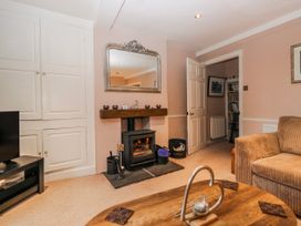 A living room with a fireplace and television at the Old Book Shop in Cartmel