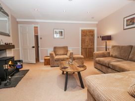 A living room with a fireplace and seating arrangements at The Old Book Shop in Cartmel