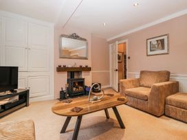 A living room with a television and coffee table at The Old Book Shop in Cartmel