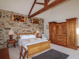 A bedroom with a bed and wardrobe at Birchenhayes St Dominick