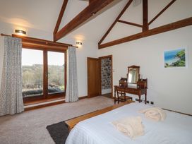 A bedroom with a bed and a dressing table at Birchenhayes St Dominick