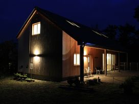 A house with lights on and chairs on the porch at Narracott Down South Molton