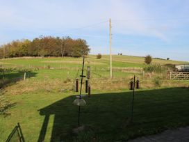 A garden with bird feeders and a view of fields at Narracott Down in South Molton