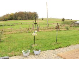 A garden with bird feeders and flower pots at Narracott Down in South Molton