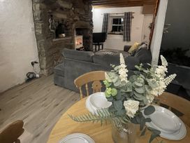 A living room with a fireplace and a sofa at Old Chapel House in Llanfairfechan