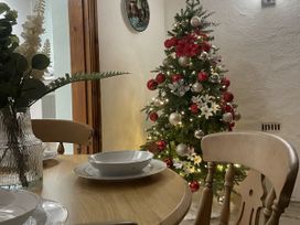 A dining room with a Christmas tree and table settings at Old Chapel House in Llanfairfechan