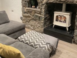 A living room with a sofa and fireplace at Old Chapel House in Llanfairfechan