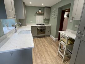 A kitchen with cabinets and a stove at Old Chapel House Llanfairfechan