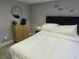 A bedroom with a bed and a dresser at Old Chapel House in Llanfairfechan