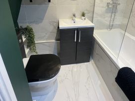 A bathroom with a sink, toilet, and bathtub at Old Chapel House Llanfairfechan