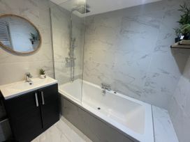 A bathroom with a bathtub and sink at Old Chapel House Llanfairfechan