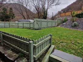 A garden with a fence and grass area at Old Chapel House Abergwyngregyn near Llanfairfechan