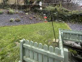 A garden with a fence and bird feeder at Old Chapel House in Abergwyngregyn near Llanfairfechan